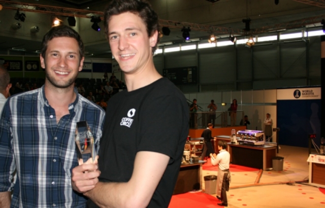 Auto News | Moritz Waldstein-Wartenberg und Martin Elwert (v.l.) von Coffee Circle mit dem SCAE Award 2012 – im Hintergrund die World Barista Championship 2012 in Wien